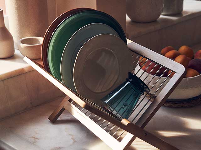 Plates on wooden stacker on marble kitchen worksurface from Zara Home AW21