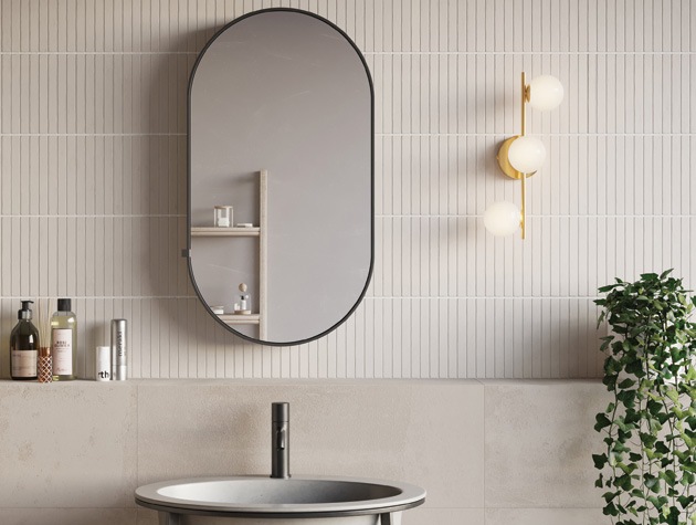bathroom lighting ideas: art deco-style brass bathroom wall light in neutral tiled bathroom 
