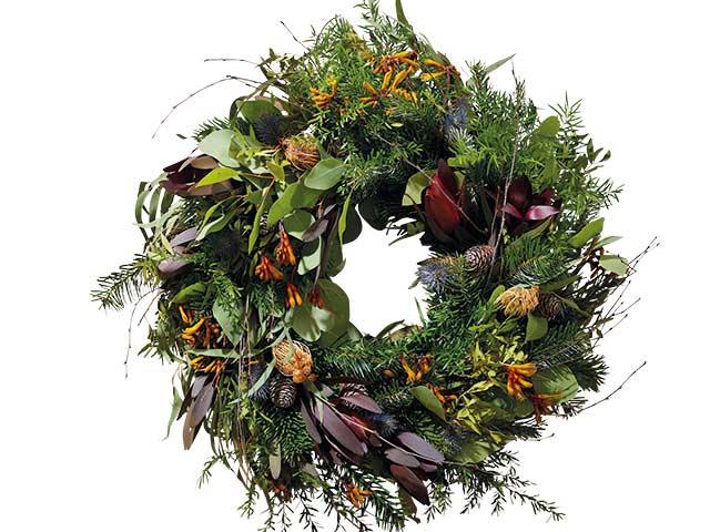 Wild Christmas wreath with fresh plants and flowers on white background