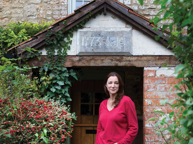 deep gabled cottage porch with dates carved into stone above the door