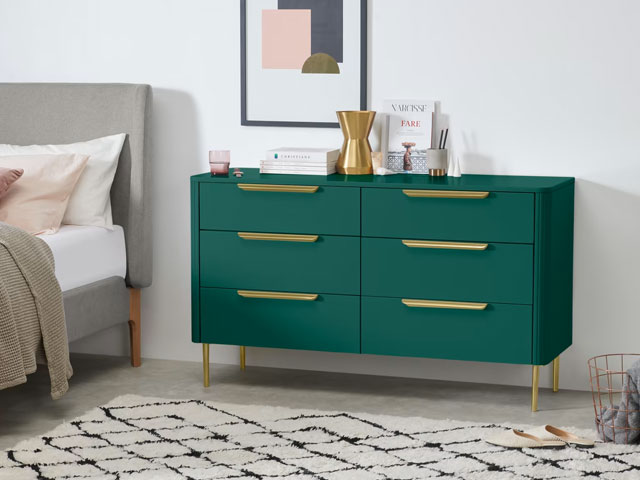 Green chest of drawers with brass gold handles and legs on white background