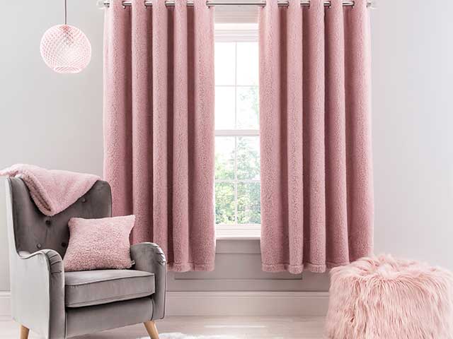 Pink fleecy curtains, charcoal armchair and pink blankets and cushions from Dunelm Teddy range