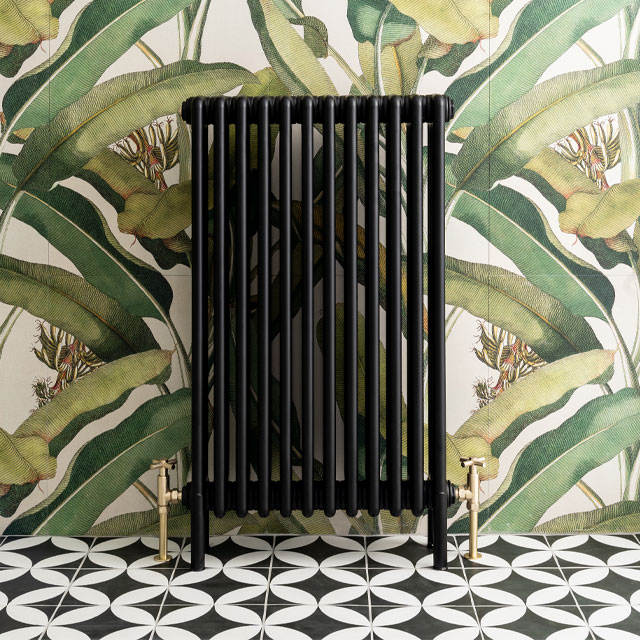 traditional column radiator in black against leaf print wallpaper