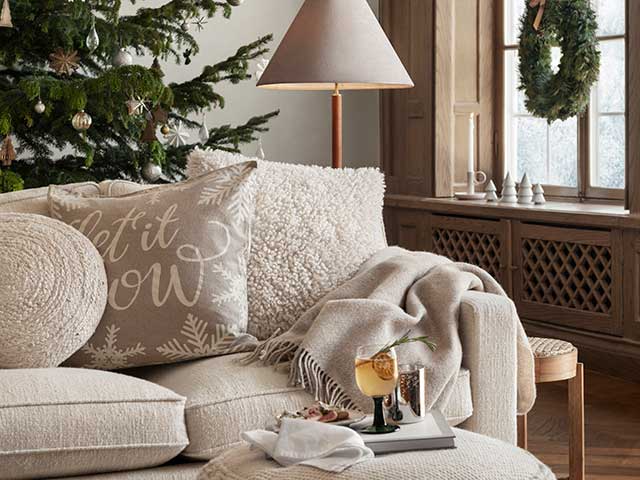 Sofa and cushions in cosy Christmas-themed festive room