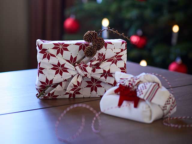 Christmas hacks sustainable wrapping on table in front of tree