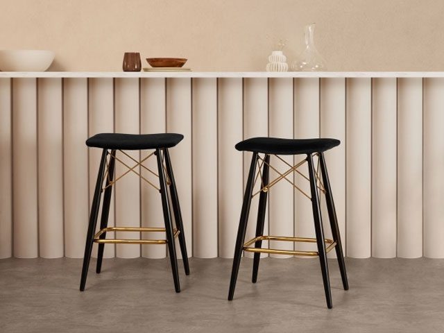 pair of black and gold counter seats at a breakfast bar with scalloped panelling  