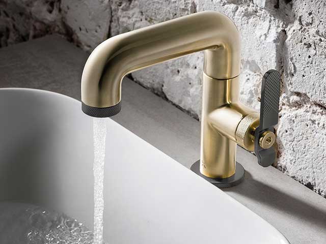 Gold sink taps with butterfly tap running water into basin