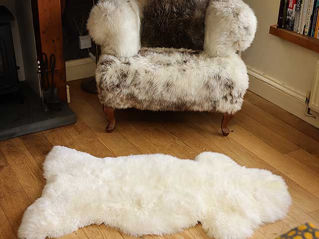 Cabincore ivory rug on wooden floor with fluffy armchair
