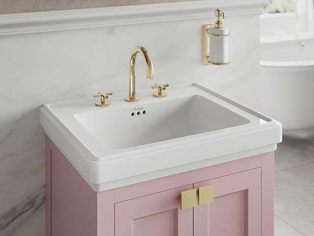 Pink unit basin with gold taps and white basin in marble bathroom