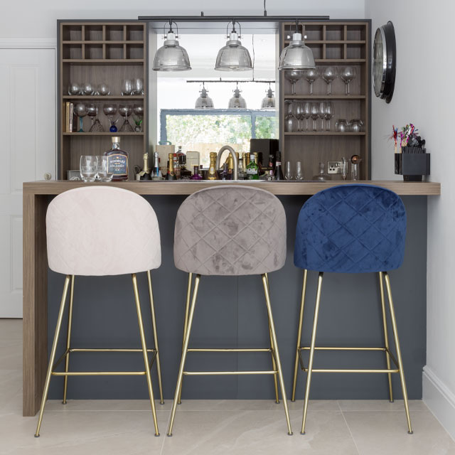 home bar with open shelving and kitchen peninsula with bar stools