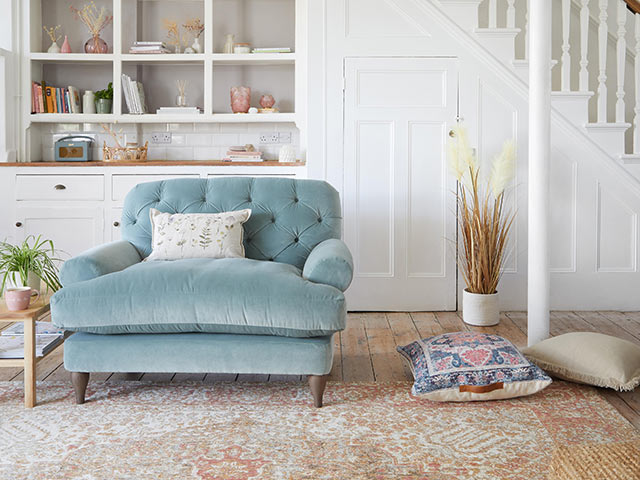 70s boho velvet blue pincushion chair in front of white storage staircase