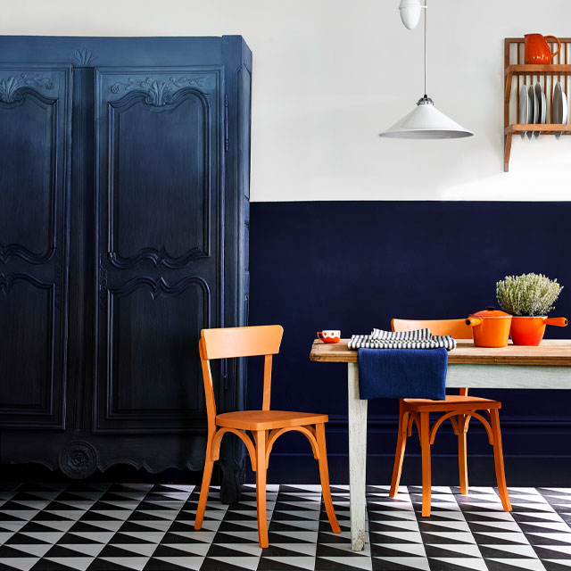 kitchen colour ideas: blue and white dining room with orange chairs and accessories and navy ombre painted cupboard