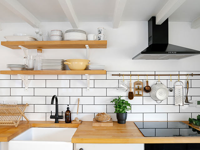 Scalet kitchen with white metro tiles and wooden worktops and shelves with white beams