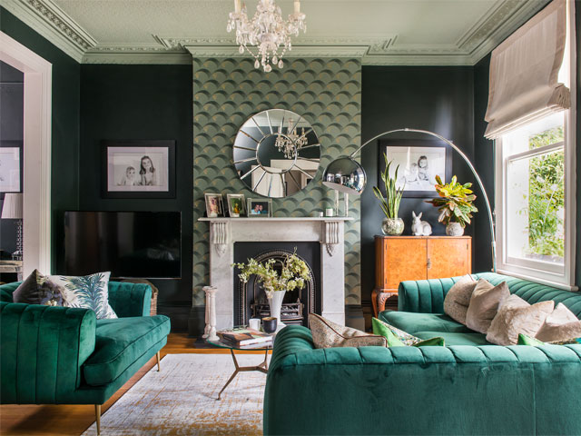 Interior designer Elinor Wright's beautiful living room with teal sofa and feature wallpaper on chimney breast