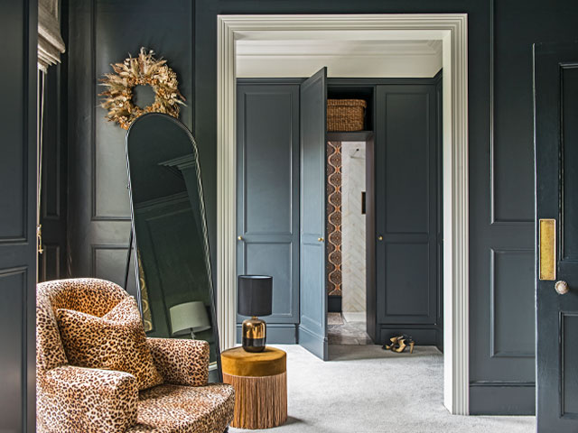 walk-in wardrobe painted black with panelled walls