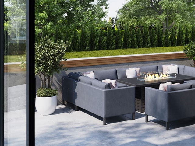 garden trends 2022: outdoor dining table with firepit and u-shaped sofa