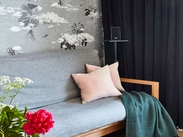 a cinema room with sofa bed, cloud wallpaper and dark curtains