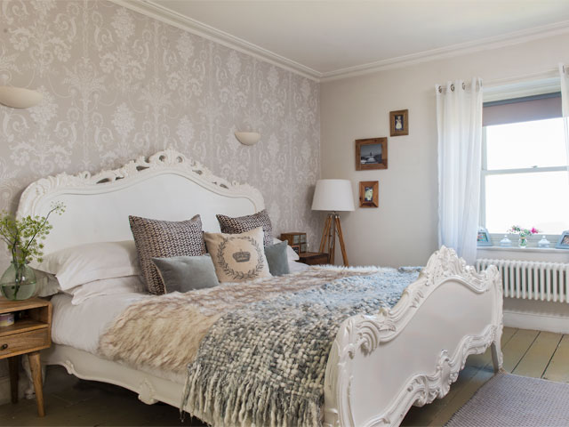The main bedroom with French-style bed and neutral decor scheme