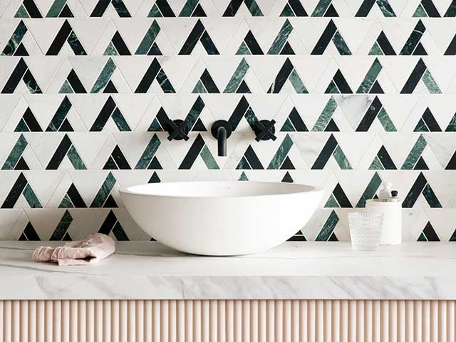 Patterned bathroom tiles on basin with marble worksurface