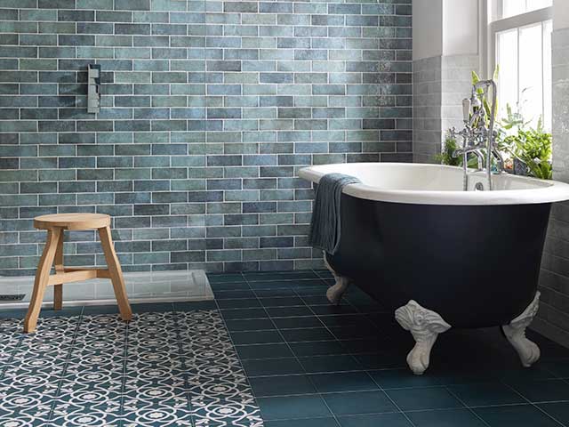 patterned bathroom tiles on floor and wall with freestanding bath