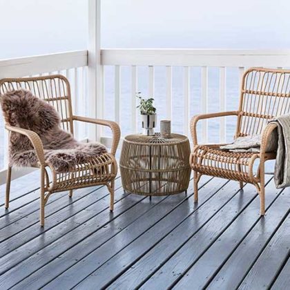 coastal grandma look terrace with wicker chairs and blankets