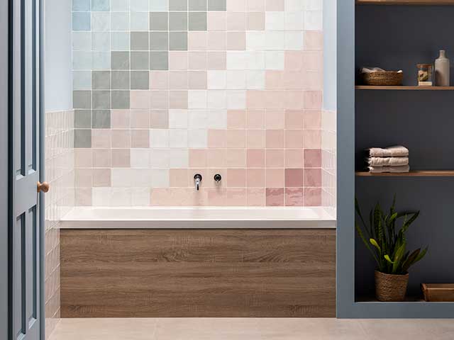patterned bathroom tiles in pastel colours over wooden bath