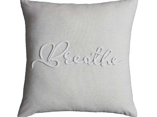 Embroidered 'breathe' cushion on white background