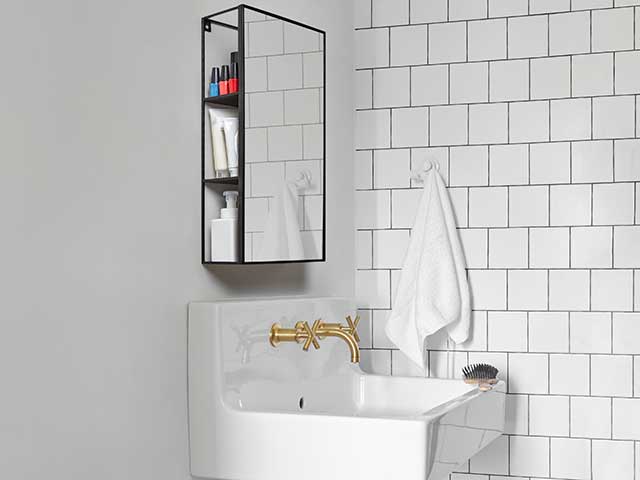 mirrored bathroom cabinet above white basin and white tiles