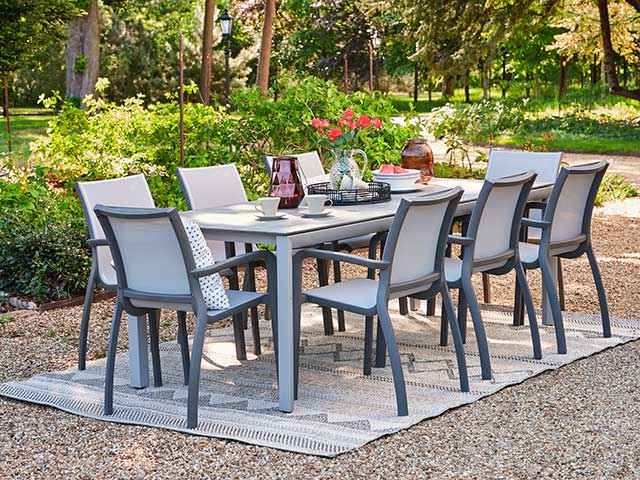 Eight seater grey garden dining sets with stackable chairs on outdoor rug