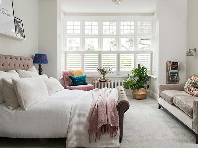 Master bedroom with pincushion headboard and sofa inside