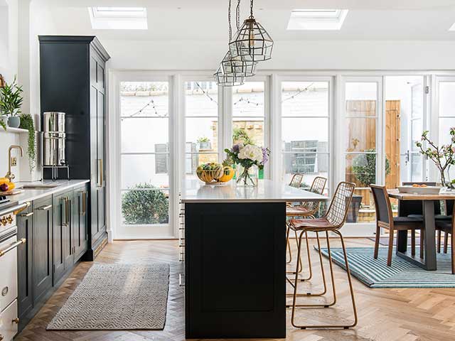 Kitchen island of kitchen diner and bifold doors leading to courtyard