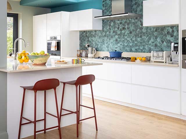 kitchen renovation with green splashback tiles and white cabinets