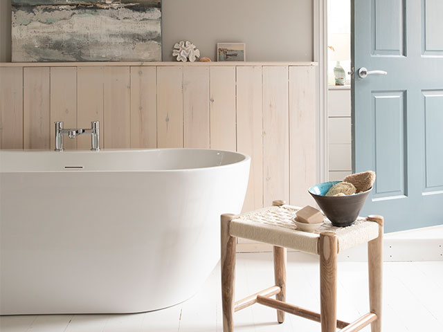 coastal decorating ideas for the bathroom: Freestanding tub and whitewash woodwork with blue door