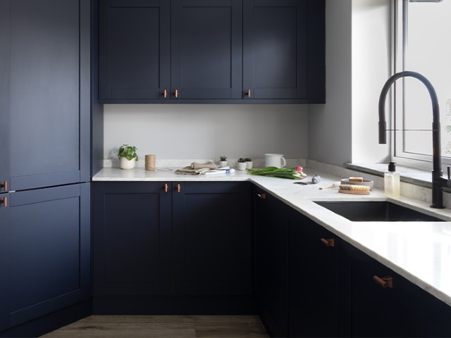 kitchen with navy cabinets, white marble worktops and large sink
