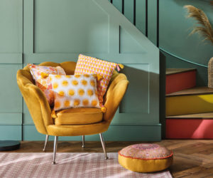 colourful hallway ideas: mustard accent chair with sage green-painted stairs and accent runners