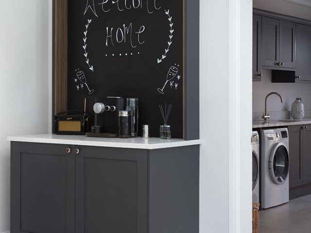 utility room with grey cabinets, chalk board wall and coffee station