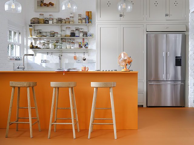 orange floor and orange island in a white kitchen