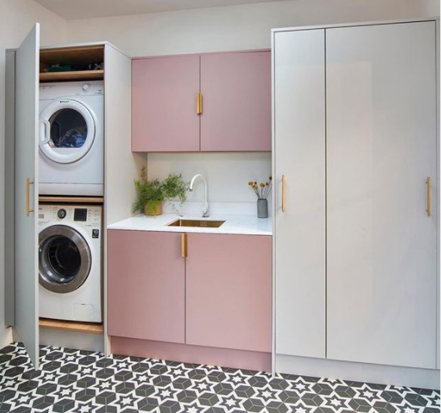 pink utility room with monochrome patterned flooring tiles and washer dryer in a tall cabinet