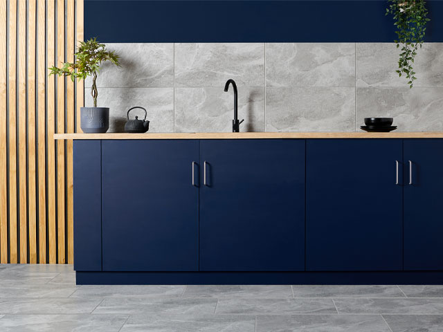 grey marble tiled kitchen splashback with blue cabinets and wooden wall panelling
