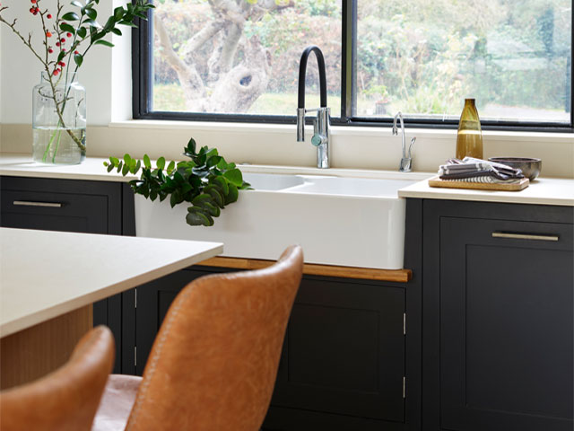 modern shaker kitchen with navy cabinets, pink highlights and tan bar stools