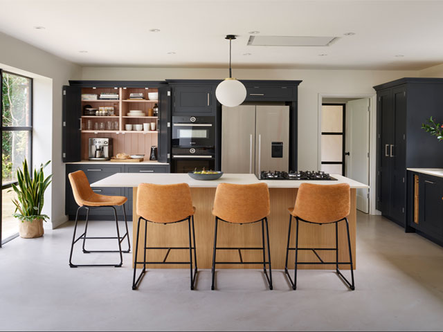 modern shaker kitchen with navy cabinets, pink highlights and tan bar stools