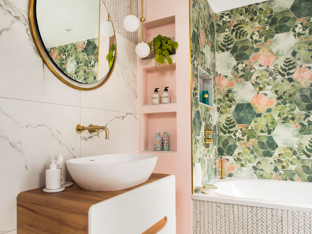 bathroom renovation with hexagonal floral print tiles and pink wall with recessed shelving 