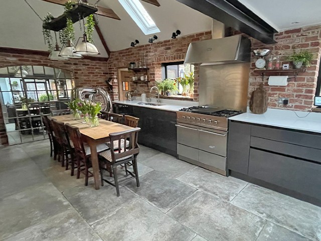 stone slabs in a kitchen conversion with exposed brick walls and exposed ceiling beams