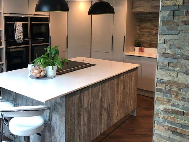 nature-inspired kitchen design with wood-clad island, stone walls and modern worktops