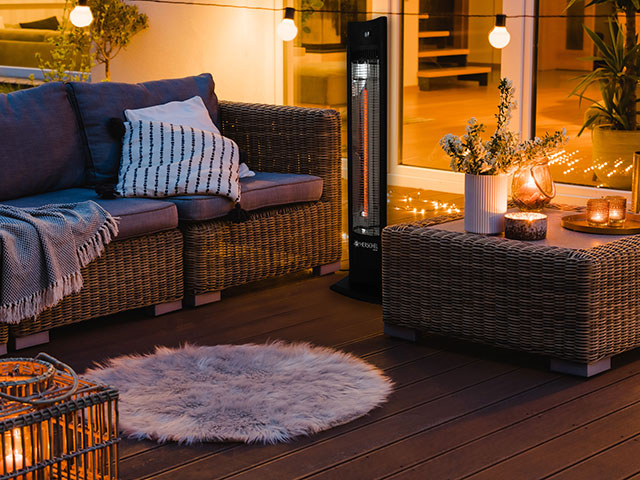 patio heater in outdoor evening space with fluffy rug and string lights