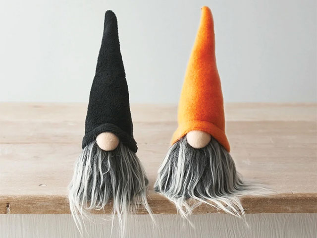 pair of wizard dolls with grey beards, pointy hats and big noses on a shelf