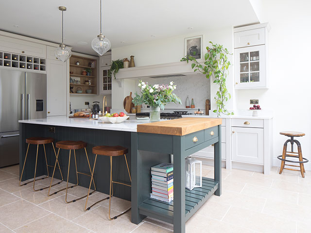 open plan kitchen extension with dark green island, wooden worktop and off-white walls