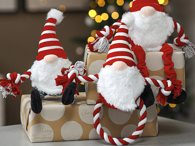 red and white striped festive dog toys sitting on gift-wrapped presents