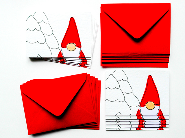 red and white cards and envelopes featuring festive nordic dolls on a white background