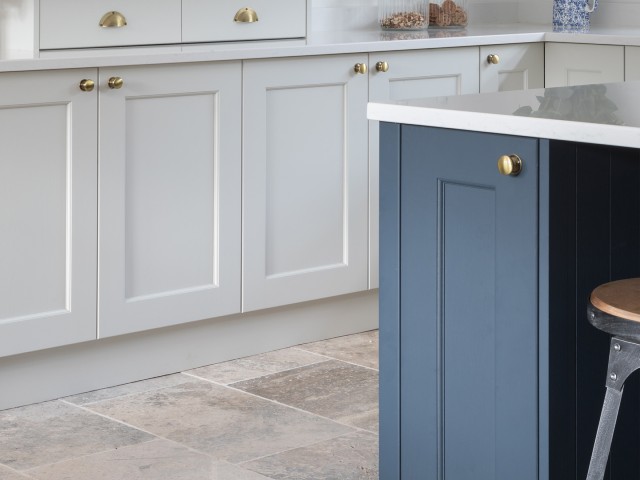 close-up of kitchen cabinets in blue and white with brass handles